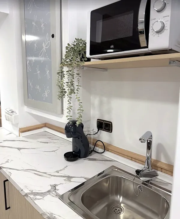 Detalle del office con cafetera y vinilo de libélulas